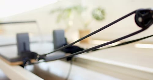 O equipamento de Pilates com alças e almofadas pretas está pronto para uso