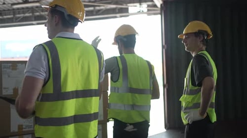 Blue collar workers are working at warehouse.