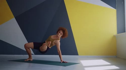 Yoga-Training drinnen Junge erwachsene Frau trainiert alleine zu Hause oder im Fitnesscenter mit Asana