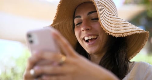 Woman in Sun Hat Using Mobile Phone