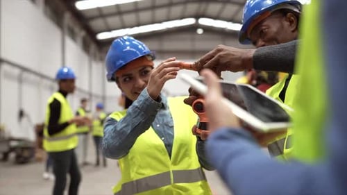 Meeting between engineers in the robotic factory - tech factory - group of multiracial co-workers of