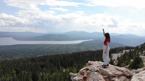 Girl Raised Her Right Hand While Standing at the Top of the Mountain