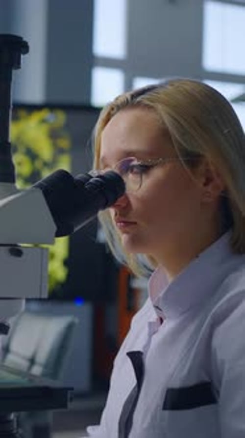 Young Woman Using Microscope in Medical Lab