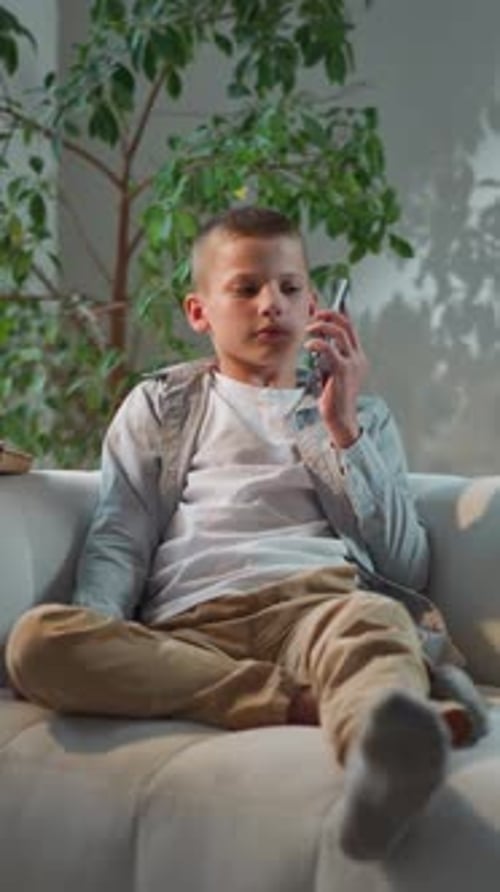 Boy on Couch Talking on Mobile Phone