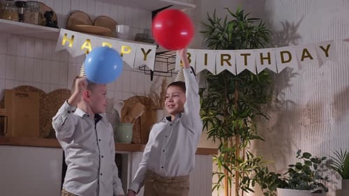 Young Boys Celebrating Birthday Holding Balloons