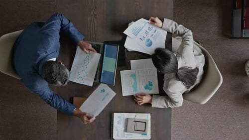 Zwei Kollegen diskutieren während der Arbeit an der Präsentation über Daten im Finanzbericht