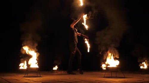 Woman Juggling Fire Torches at Night in Dark