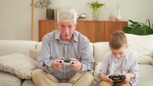 Grandfather and Grandson Playing Video Games on Couch