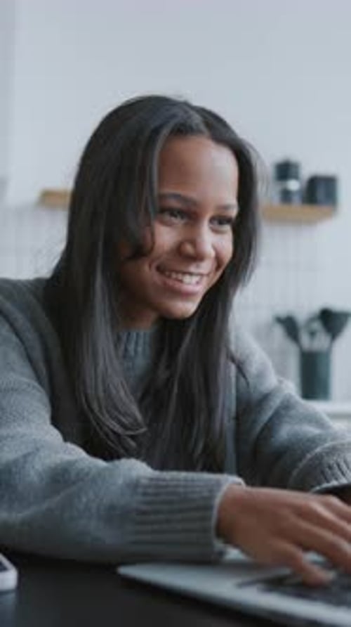 Pretty Black Woman Chatting Online in Social Media Vertical Portrait at Home Interior Internet