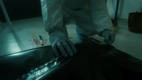 Gloved Person Sealing a Dark Body Bag
