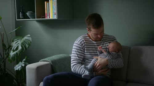 Ein Mann kümmert sich um sein Baby und singt Wiegenlieder