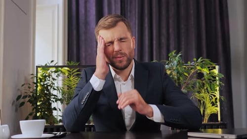 Stressful Businessman Having Painful Headache Sitting in the Restaurant