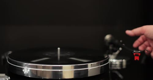 Hand Places Needle on Spinning Vinyl Record Player