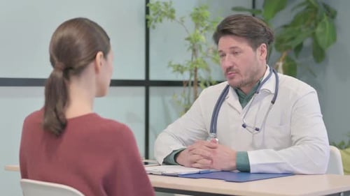 Male Doctor Talking with Patient in Clinic