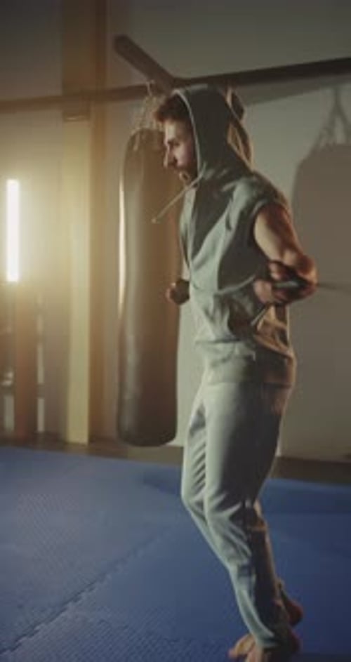 Muscular Man Cardio Workout with Jump Rope in Sport Club