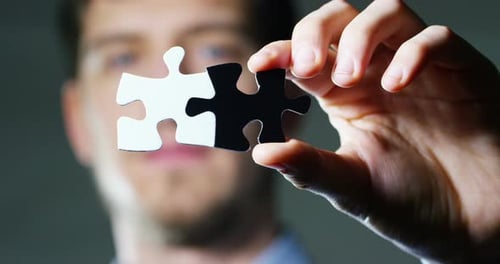 Connected Puzzle Pieces Held in Hand Close Up