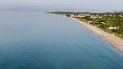 Aerial view of a coastal resort town with sandy beach and turquoise water.