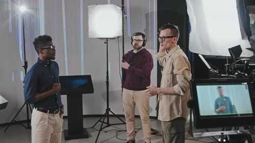 Male Operator And Gaffer Organizing Shooting Process In Studio