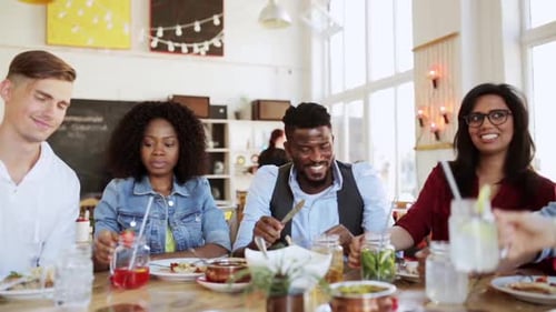 International friends celebrating friendship toasting drinks at restaurant