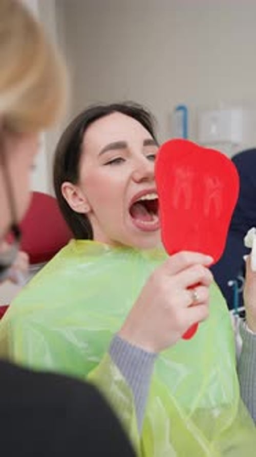 Blonde Female Dentist Tells Teeth Treatment Plan Patient in Dental Office