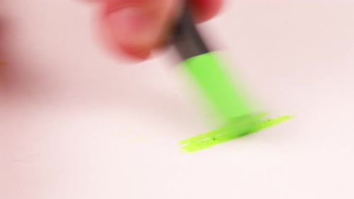 Zeichnen mit einem lindgrünen Buntstift auf einem Blatt Papier.