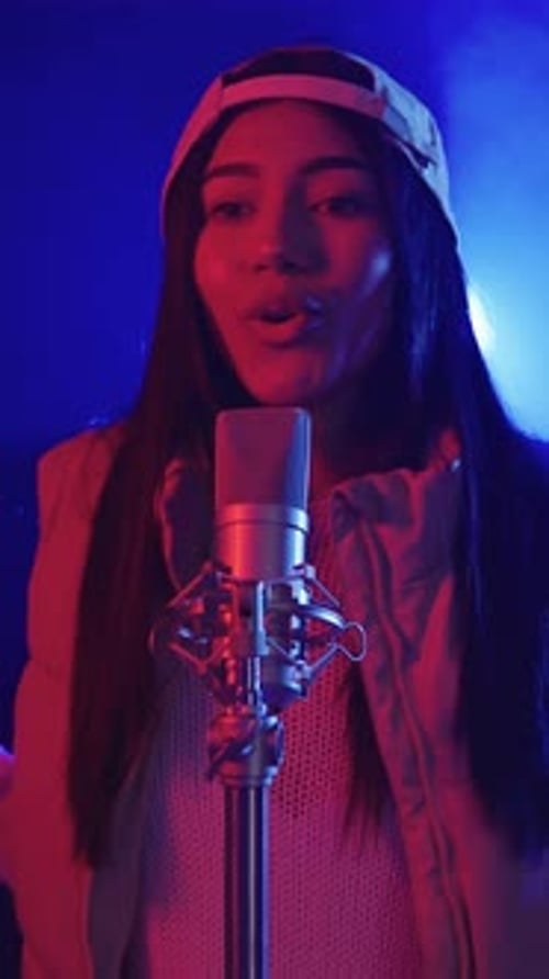 Young Woman Singing Passionately Into Microphone on Stage
