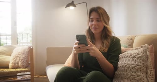Woman Relaxing Indoors Using Cellphone