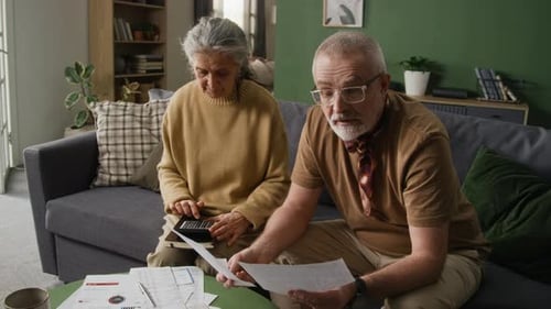 Senior Couple Reviewing Bills and Finances at Home