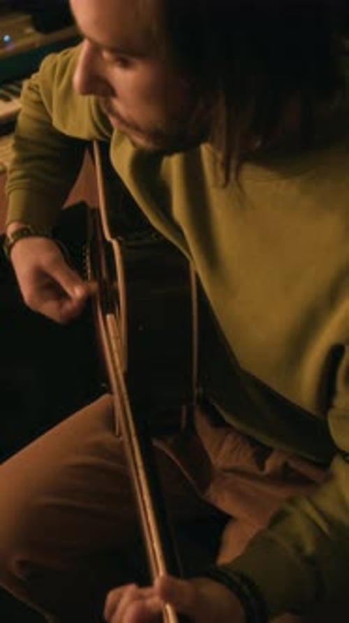 Vertikale Ansicht eines Mannes, der Gitarre mit Plektrum spielt