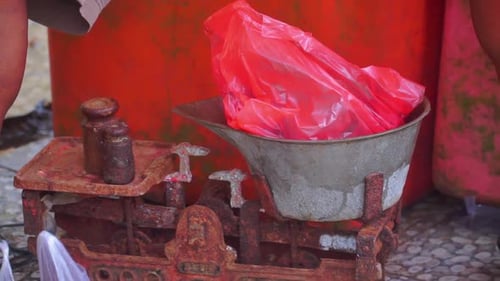 Items on the plastic bag weighed using old vintage iron scale - Indonesia traditional market