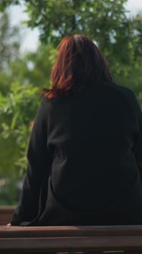 Mujer sentada en el banco del parque disfrutando de un ambiente relajado en un parque urbano