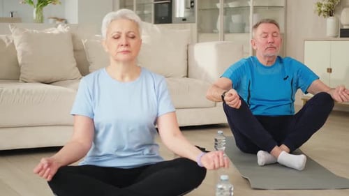 Mature Couple Meditating Together at Home