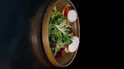 Vertical Video Close Up in a Professional Kitchen on Clean Metal Table a Woman Chef Collects a Salad