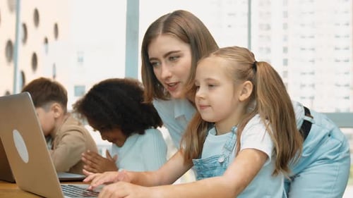L'élève utilise le code d'un ordinateur portable pendant que l'enseignant explique le programme. Érudition
.