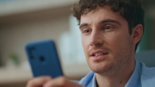 Happy Freelancer Chatting Online Looking Smartphone Screen in Office Closeup