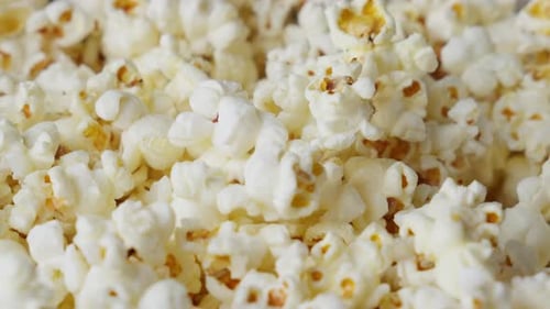 Popcorn popping and falling into the pile. Close up