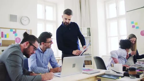 Young businesspeople collaborate with laptop in a modern open office space