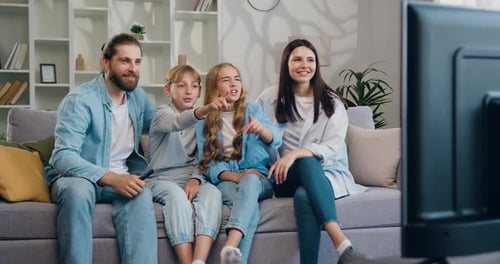 Cheerful Family of Four Watching TV Together