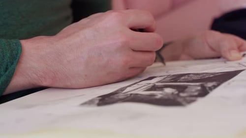 Extreme close up shot of artist's hand drawing picture on sketch pad with pencil