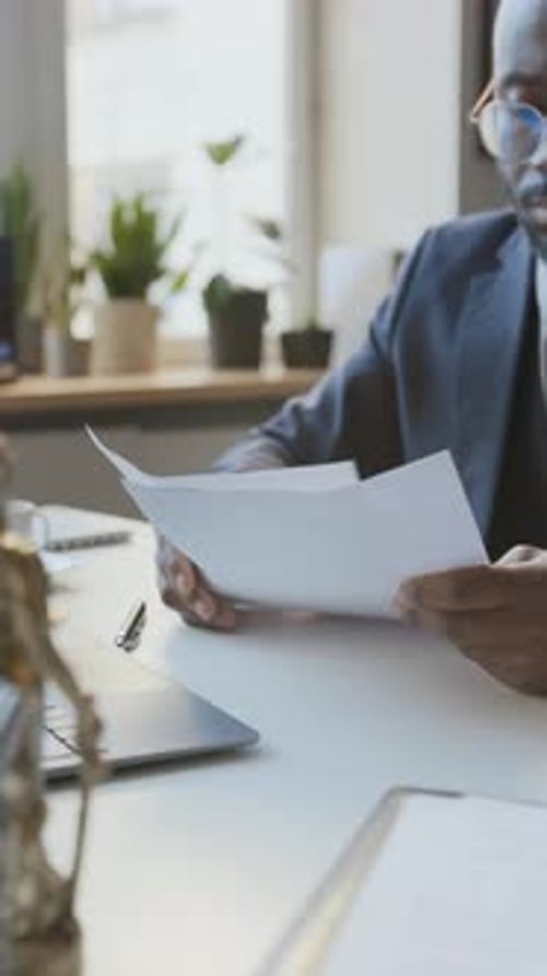 Lawyer Stamping Official Documents at Office Desk