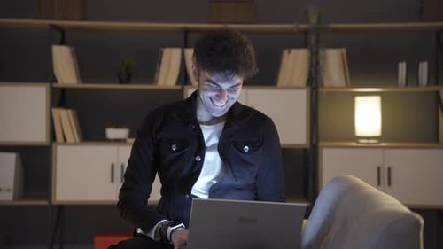 Young Adult Male Using Laptop at Night