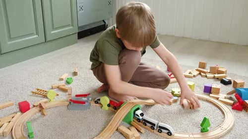 Boy Playing with Wooden Toy Train Set