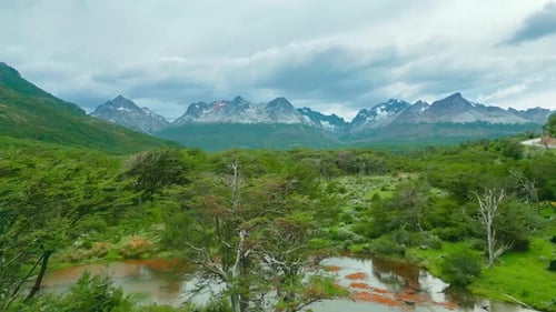 Aerial view of lush greenery, a winding river, and mountainous landscape in Tierra del Fuego, Ushuai