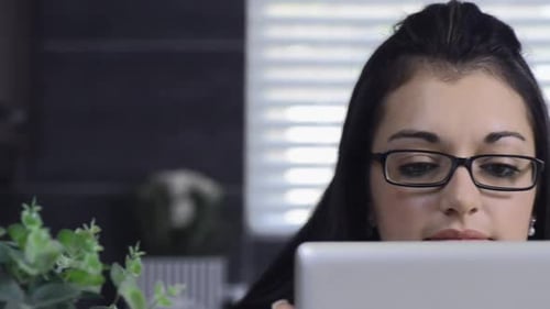 Woman Using Tablet Device at Home by Window