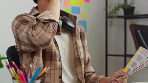 Close up of creative artist drinking coffee from coffee cup while drawing sketches on office desk