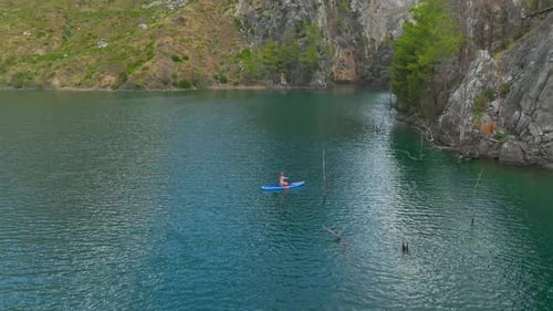 Aerial View Scenic Paddleboarding Adventure Through a Green Canyon