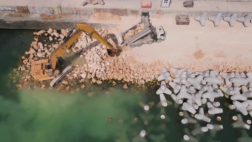 An Excavator Diligently Constructs a Dock or Breakwater in the Sea Its Mighty Arm Reaching Out From