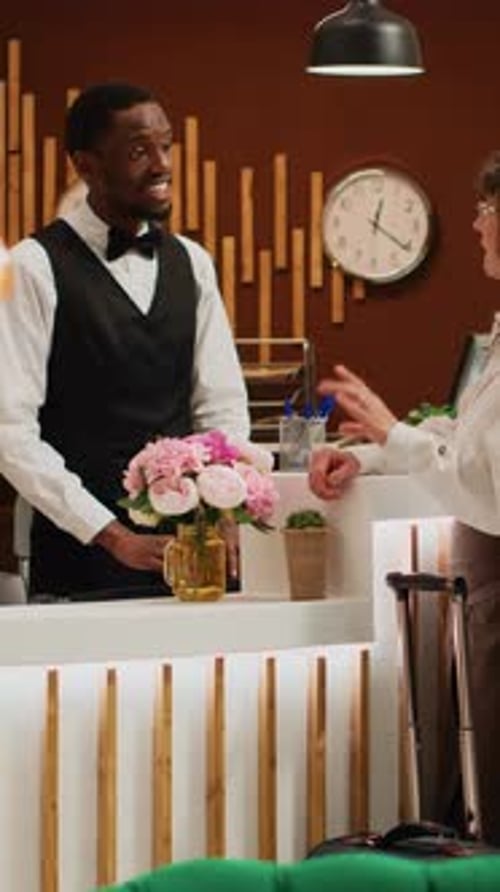 Hotel Employee Helping a Guest at Reception Desk