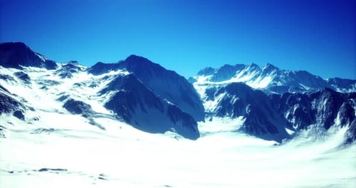 Flying Over Majestic Snowy Mountains Under Clear Blue Sky