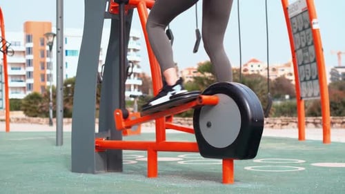 Enjoying an Outdoor Workout on Fitness Equipment at a Sunny Park